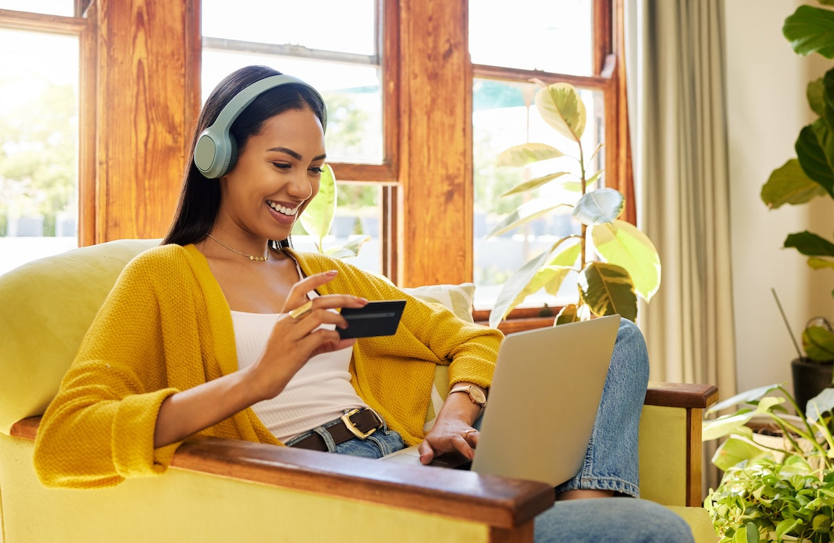 Ethnically ambiguous young woman shopping online at home