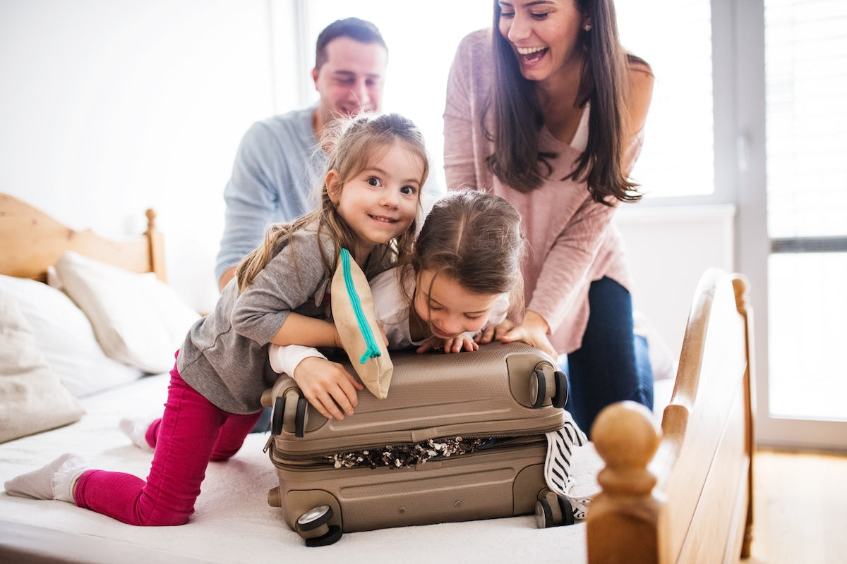 Caucasian family with two little girls packing for a vacation