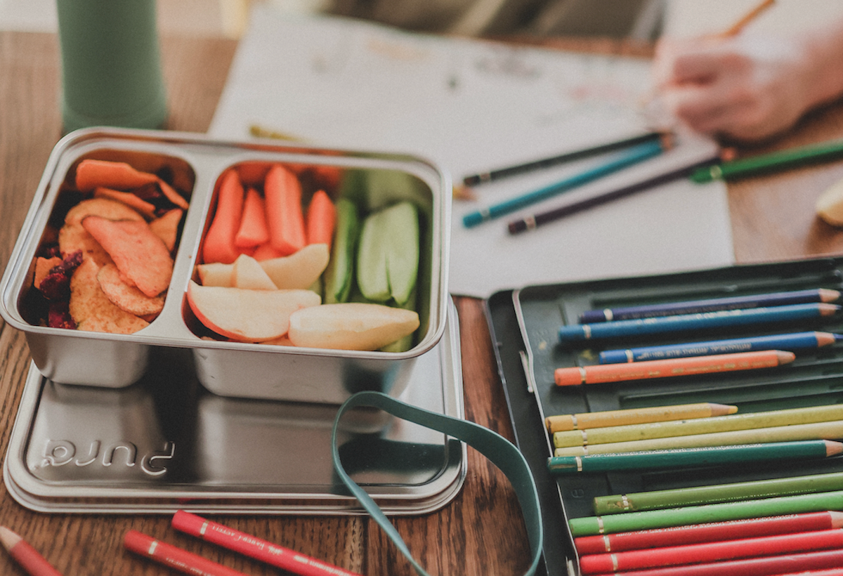 Pura stainless steel food storage container lunchbox on a child’s desk.