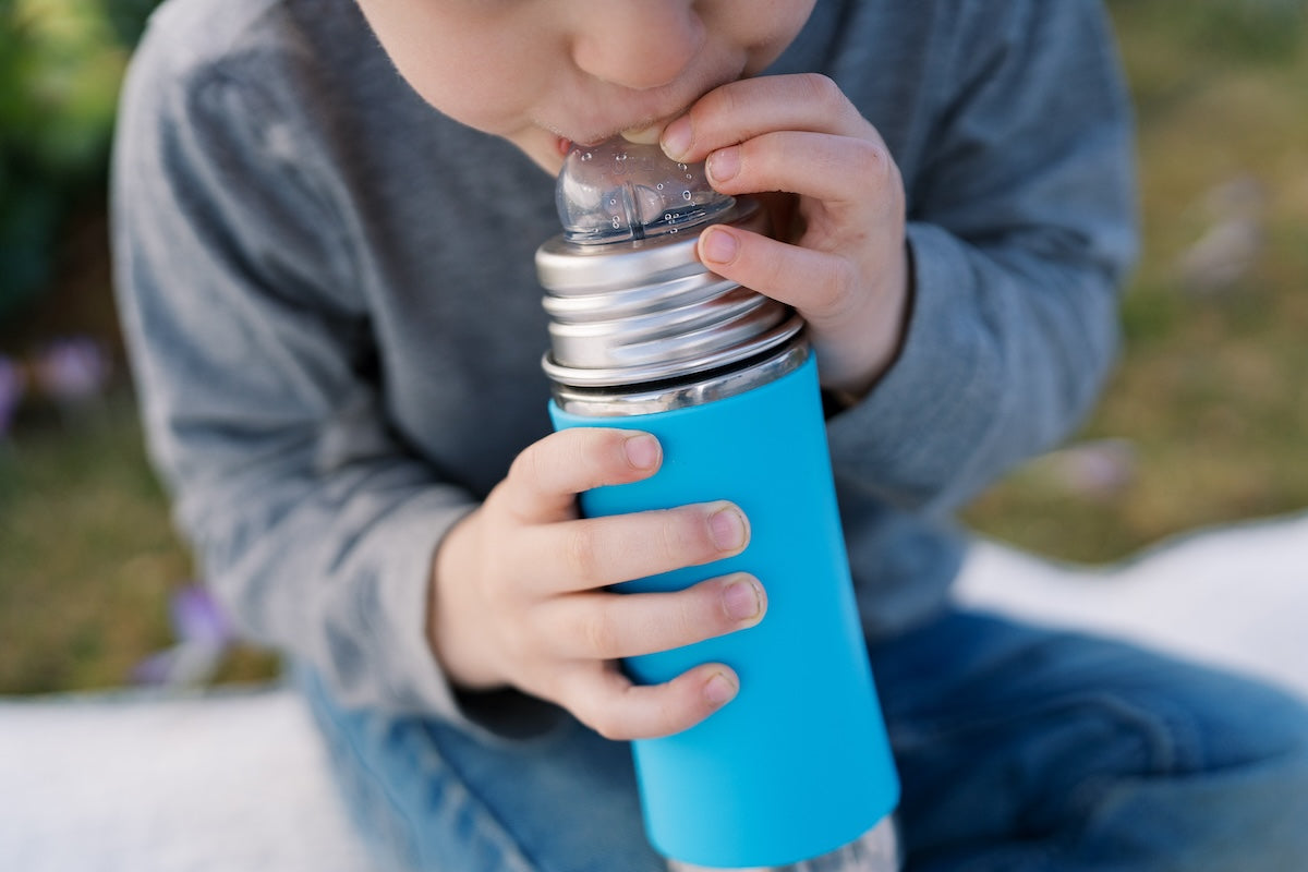 Toddler drinking from a Pura Stainless plastic-free sippy bottle.