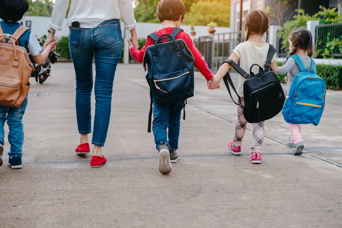 Teacher and students holding hands in a row while walking