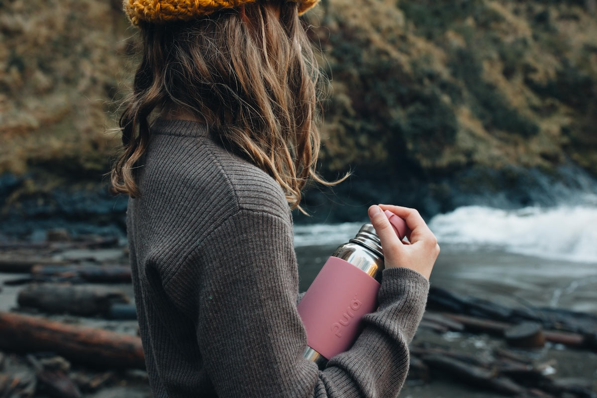 Tween holding a pink stainless steel water bottle