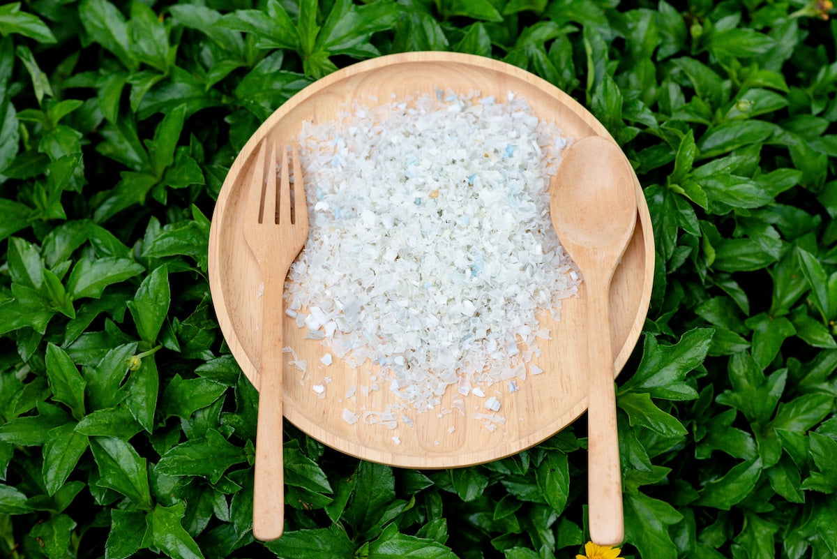 A pile of microplastics on a plate next to a fork and spoon