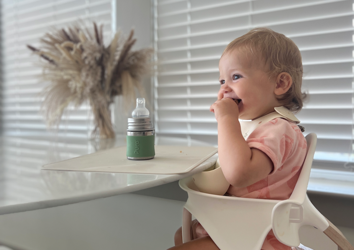 Toddler girl learning how to transition from bottle to sippy