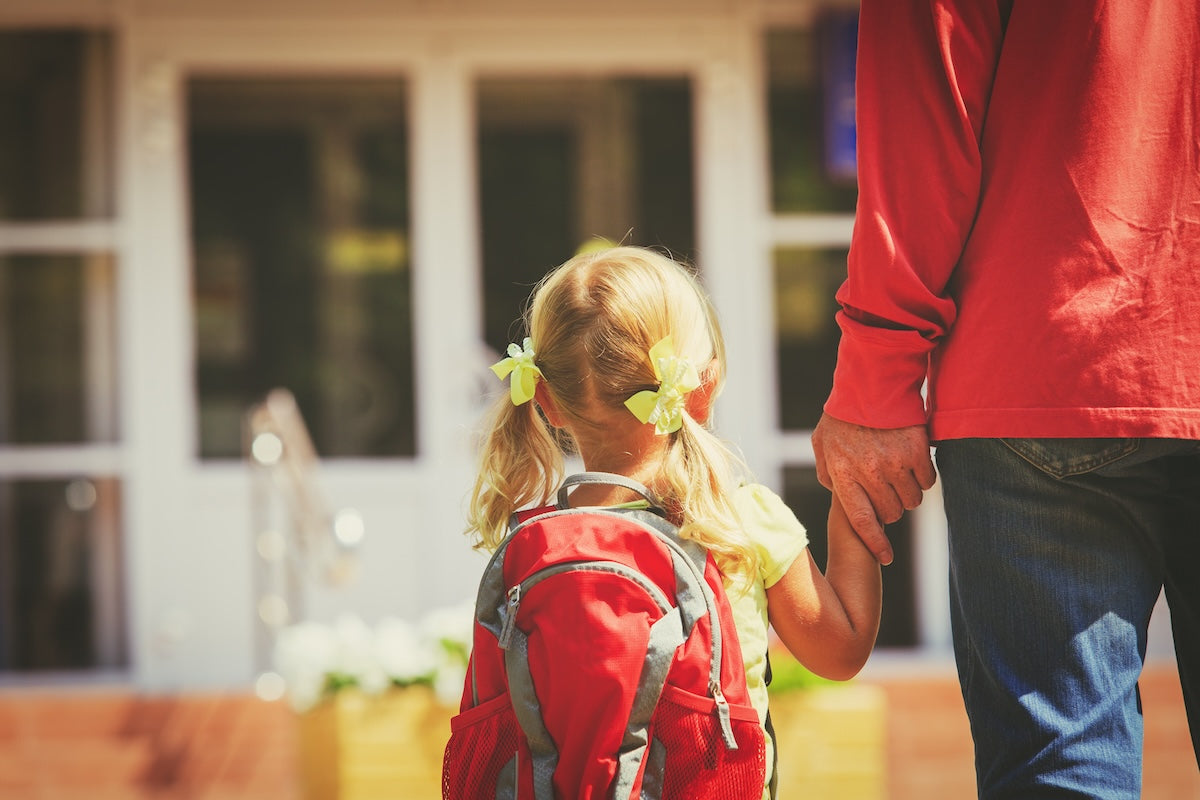 Caucasian father walking his blonde toddler daughter to school