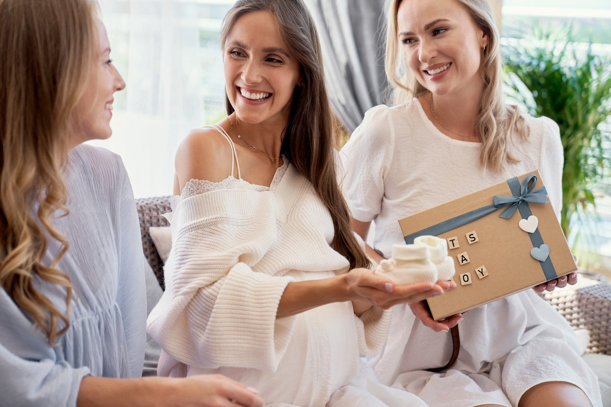 Caucasian pregnant mom opening gifts at a spring baby shower.