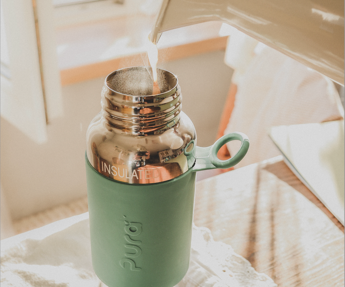 Hot tea being poured into a stainless steel water bottle